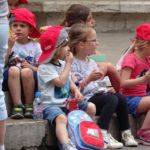 Een schoolklasje onder begeleiding van ouders dat de lunch verorbert.